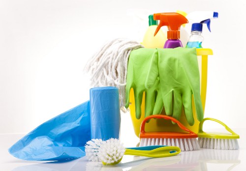 Staff member applying carpet cleaning with protective gear